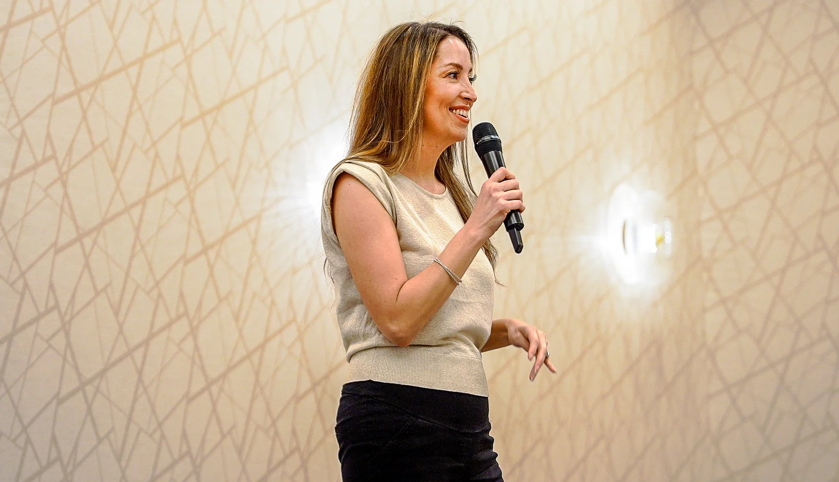 Female keynote speaker presenting with microphone at business conference