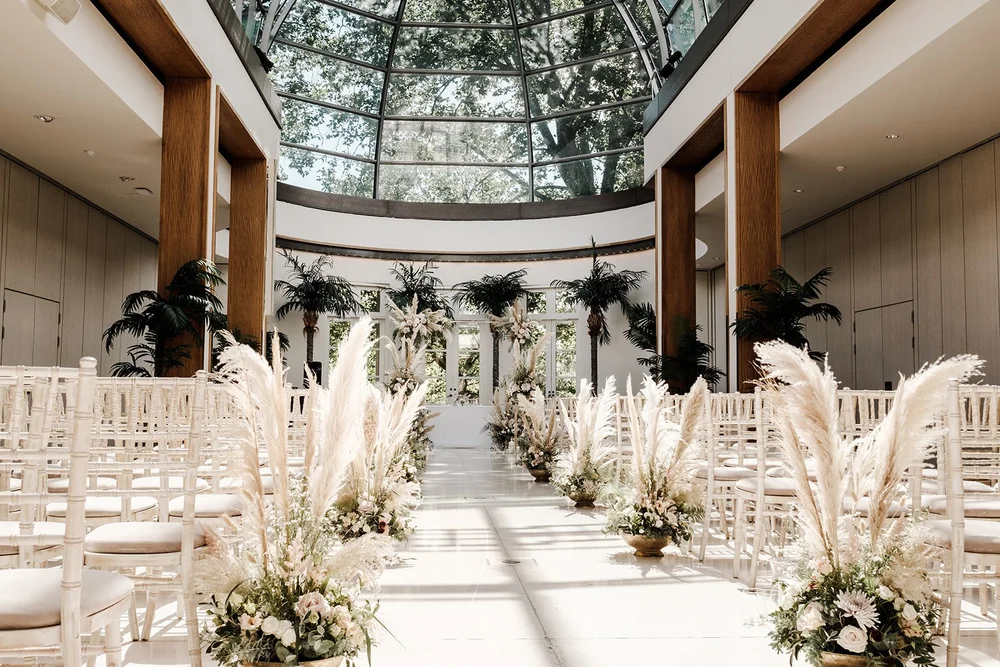 The glass-roofed Palm Court at The Hurlingham Club set for a wedding ceremony
