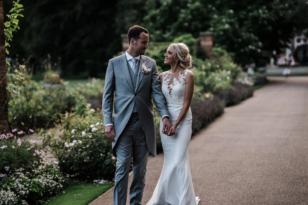 Mike and Katie walking together through the rose gardens at The Hurlingham Club