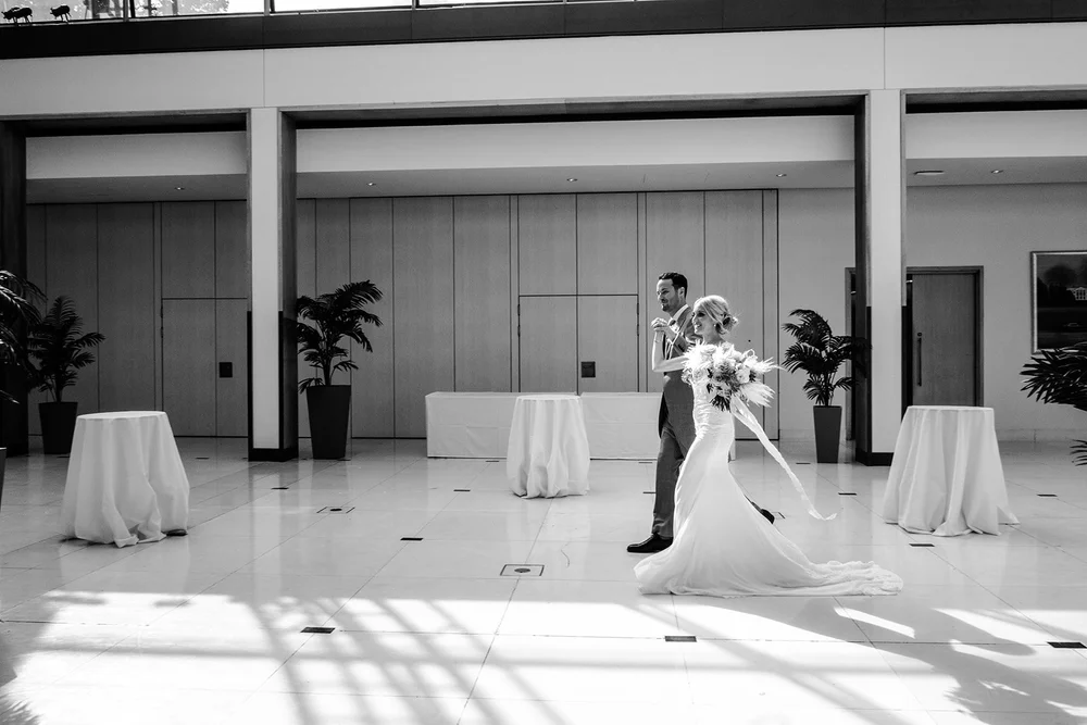 Black and white photograph of Katie alone in the empty reception room