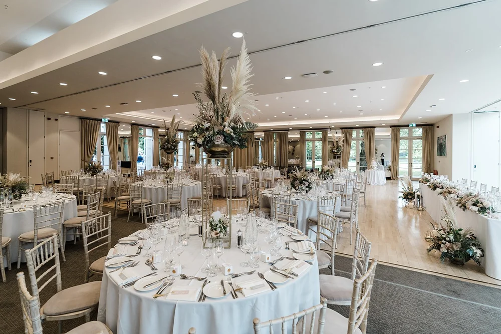 The wedding breakfast tables set beneath the glass roof at The Hurlingham Club