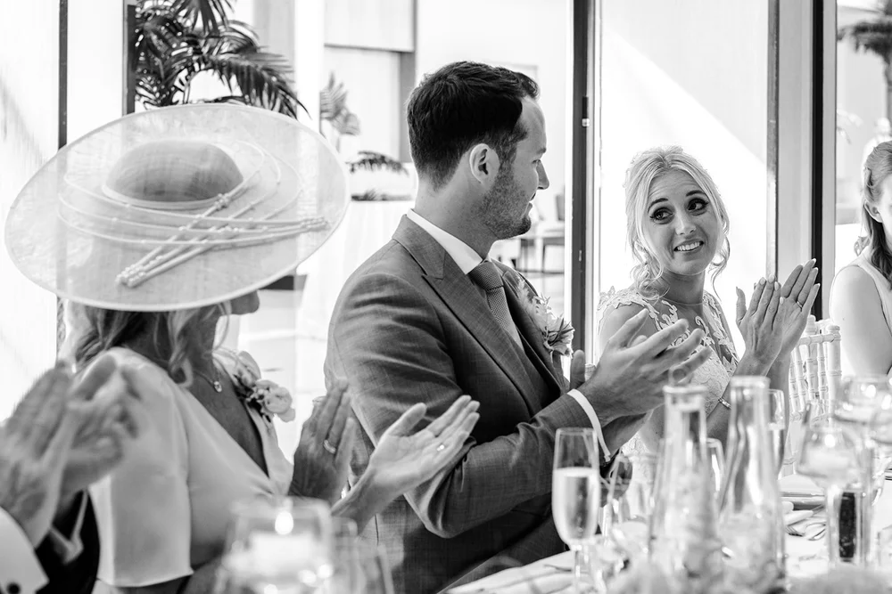 Black and white photograph of a guest in a wide-brimmed hat during the speeches