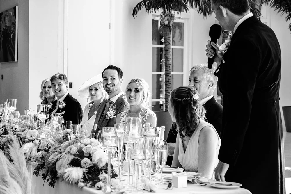 Black and white photograph of Mike and Katie cutting through the tables to greet guests