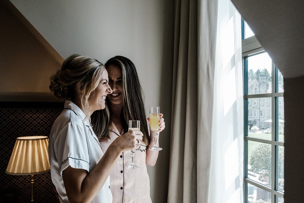 Bernie and a bridesmaid toasting with champagne before the ceremony