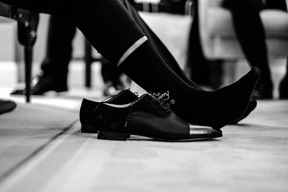 Black and white detail of patent shoes as the groomsmen get ready