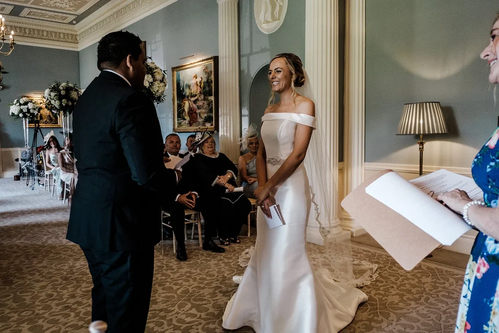 Bernie and Naesan signing the register in the ceremony room at Grantley Hall