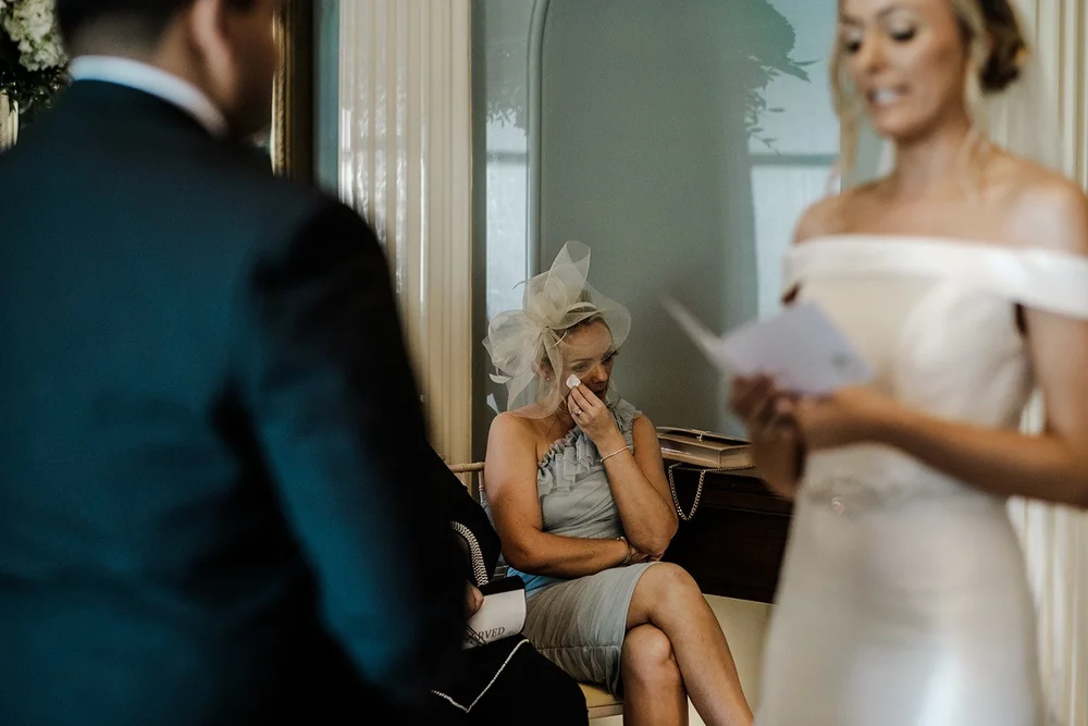 A guest wiping away a tear during a reading at Grantley Hall