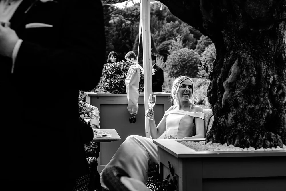 Black and white photograph of a guest watching the ceremony from the garden