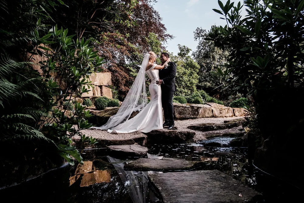 Bernie in her wedding dress on the stone path in the Japanese garden at Grantley Hall