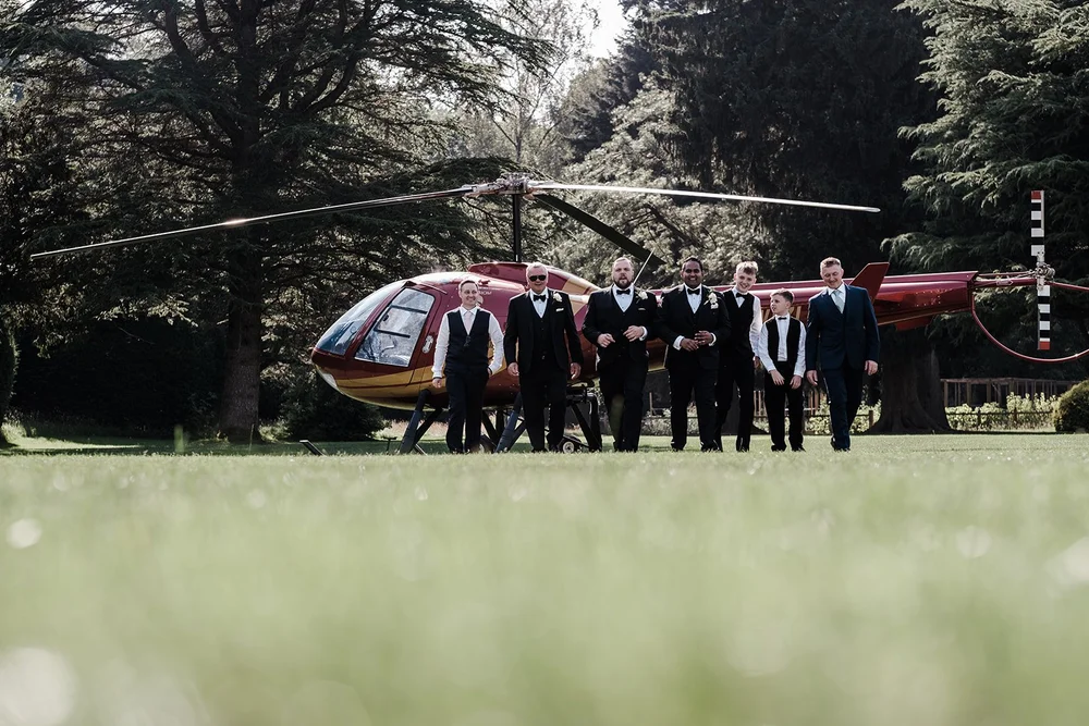 The groomsmen photographed beside the helicopter on the lawn at Grantley Hall