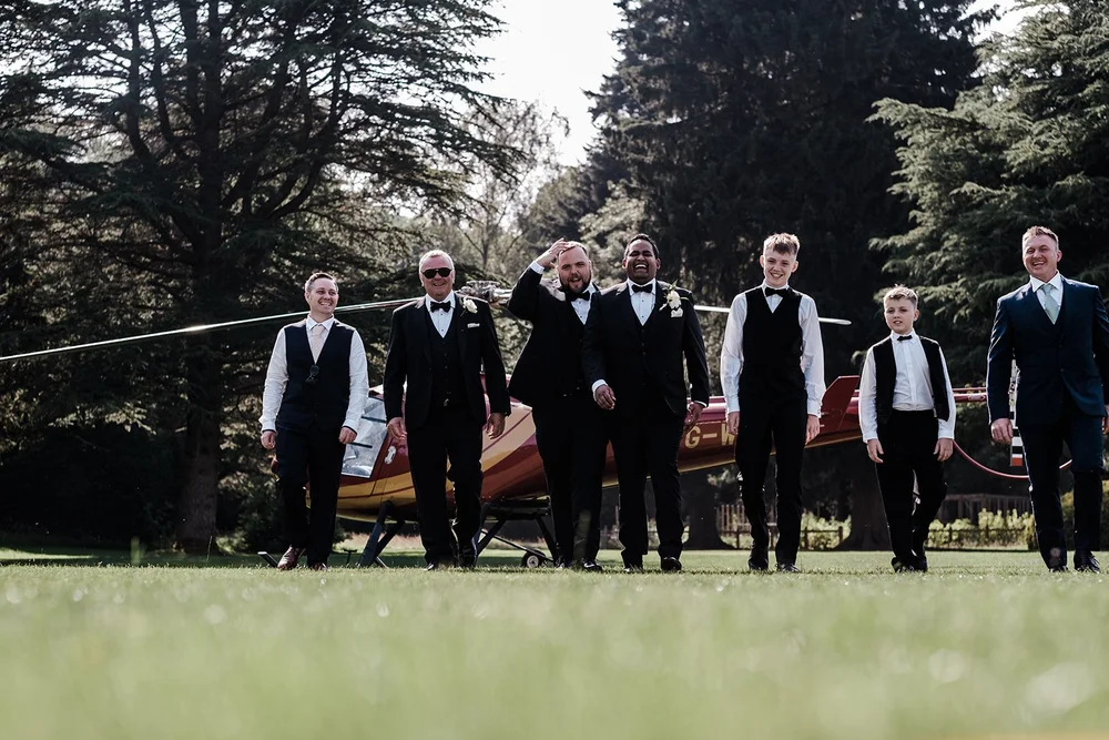 The groomsmen walking across the lawn at Grantley Hall
