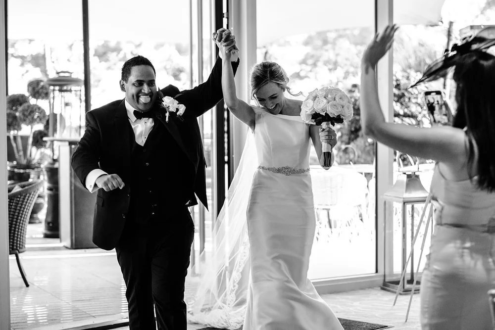 Bernie and Naesan celebrating with their arms in the air at Grantley Hall
