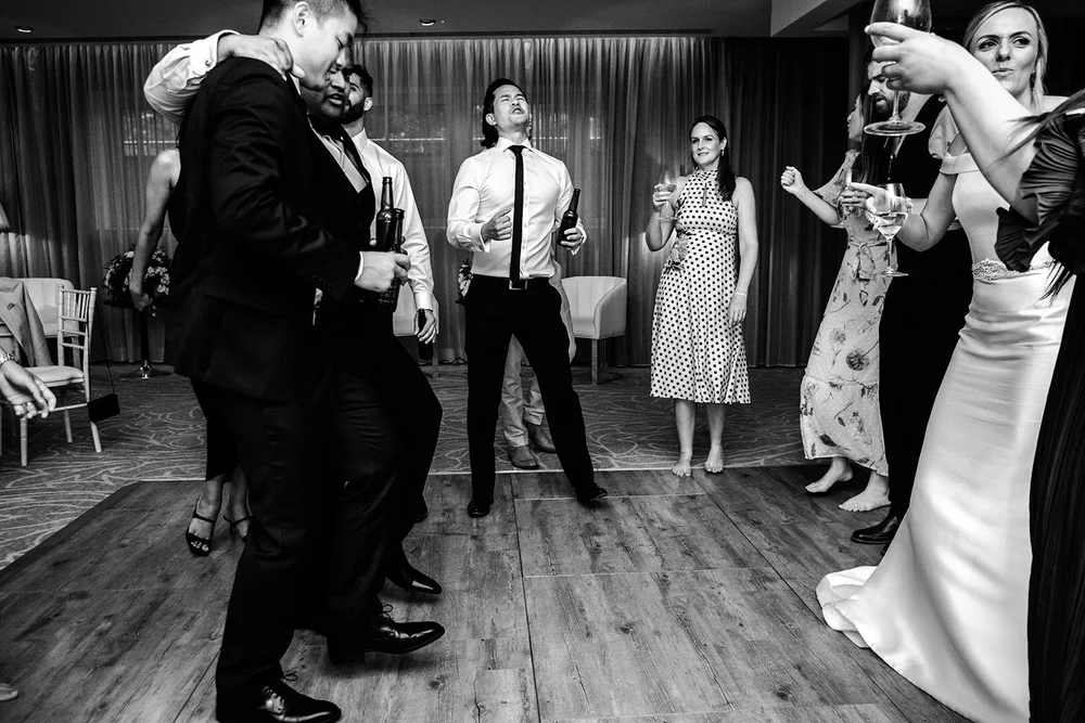 Black and white photograph of a guest dancing at the reception