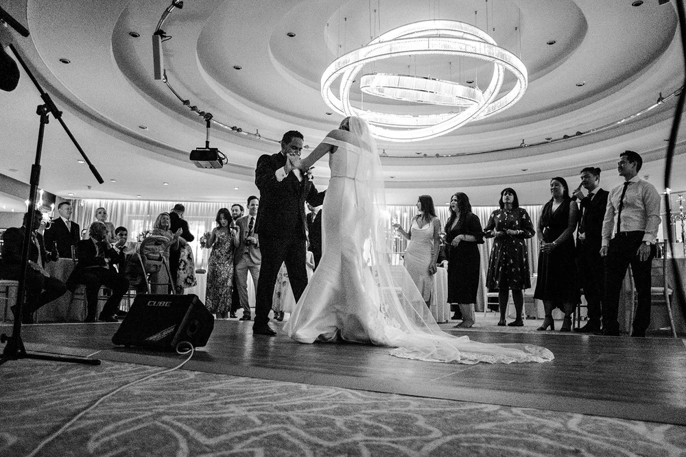 Black and white photograph of Bernie and Naesan on the dance floor beneath the ceiling light