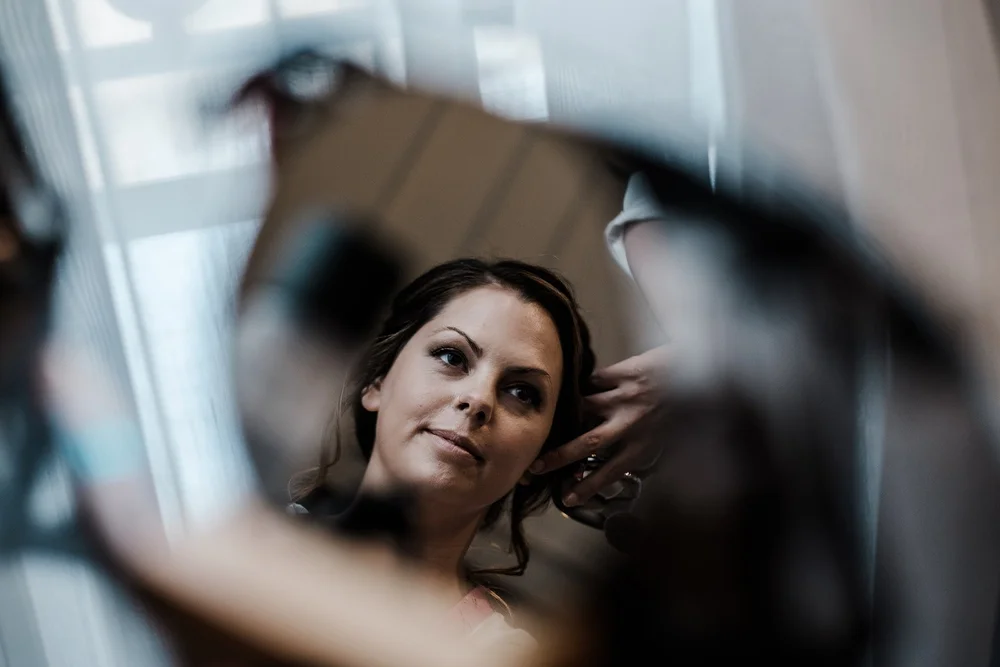Black and white photograph of Anna reflected in a mirror during preparations