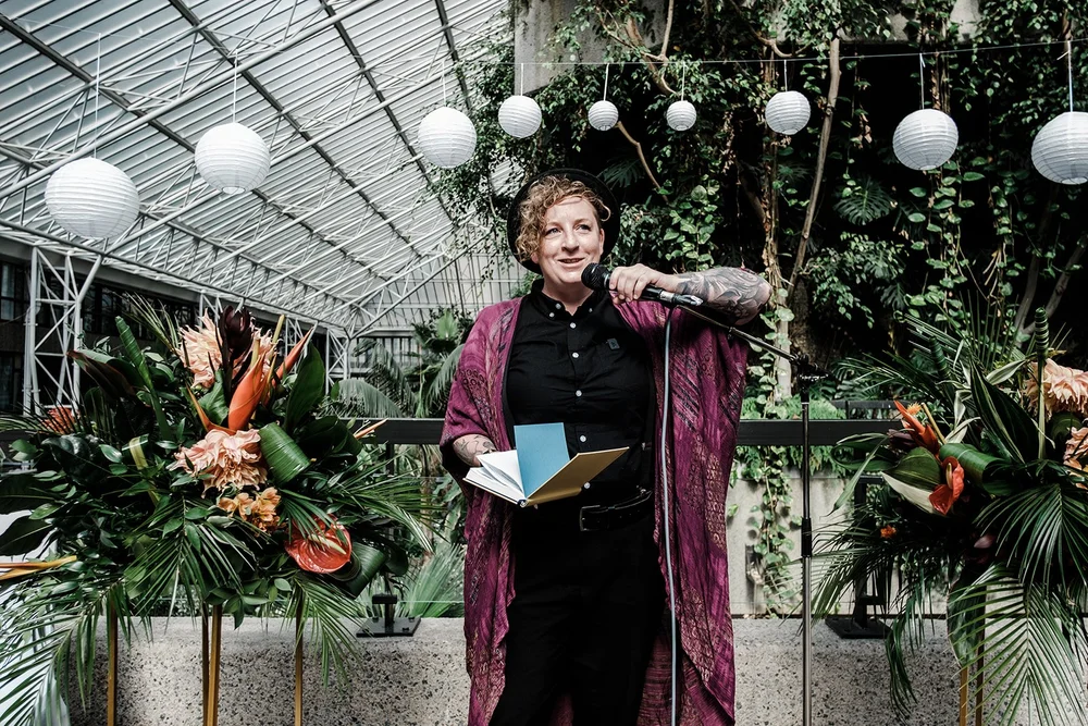 The celebrant leading the ceremony among the planting in the Barbican Conservatory