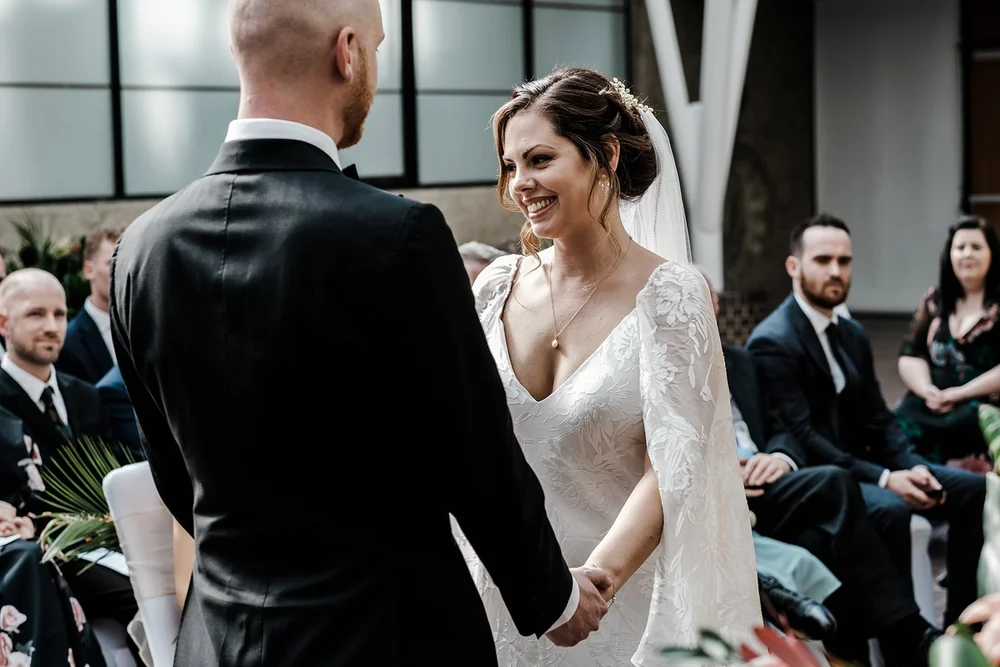 Jordan and Anna holding hands during the ceremony in the Barbican Conservatory