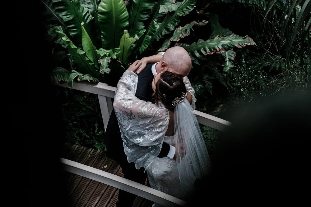 Anna in her wedding dress among the ferns in the Barbican Conservatory