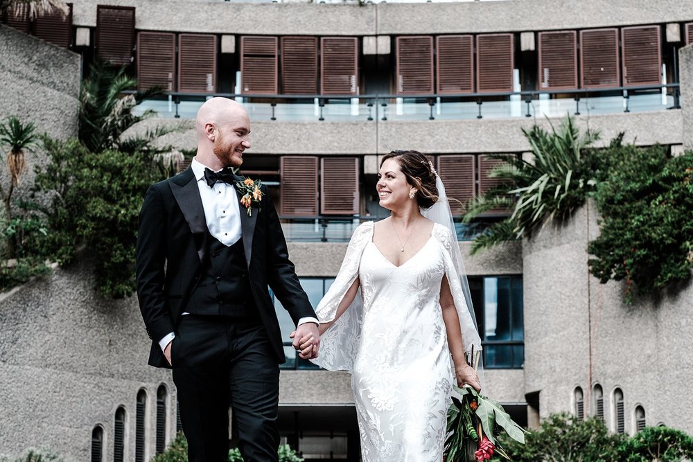 Jordan and Anna on the walkway at the Barbican with the brutalist facade behind them