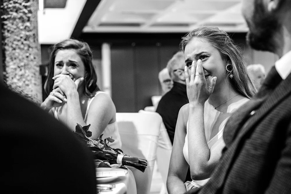 Black and white photograph of guests welling up during a speech