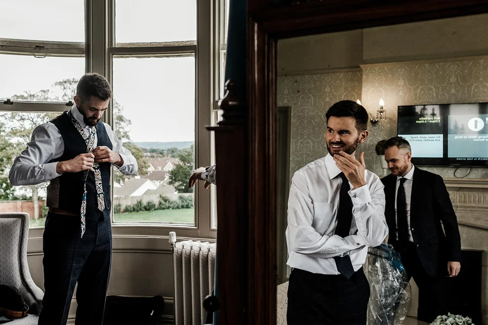 Josh and his groomsmen getting ready in the bay window at Clevedon Hall