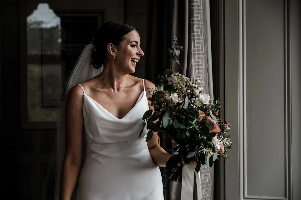 Sarah with her bouquet in the light of the drawing room at Clevedon Hall