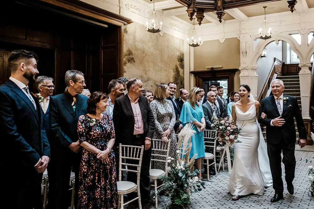 Sarah walking in with her father as the room stands, Clevedon Hall wedding ceremony