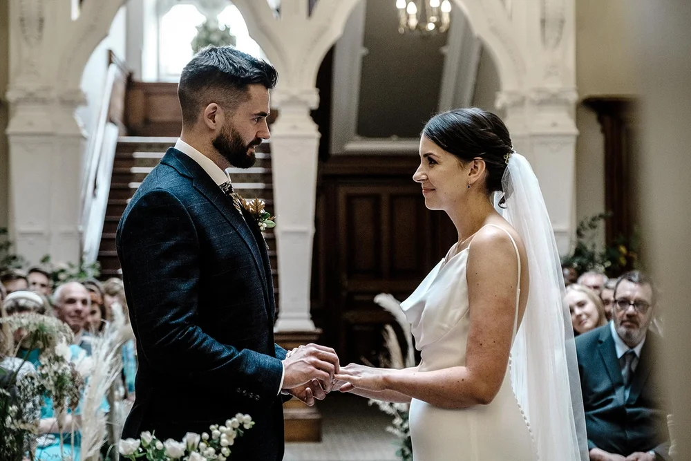 Sarah and Josh exchanging rings during the ceremony at Clevedon Hall