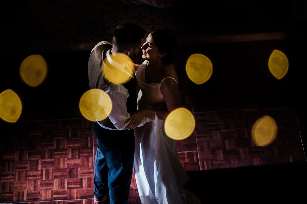 Sarah and Josh dancing under the lights at Clevedon Hall