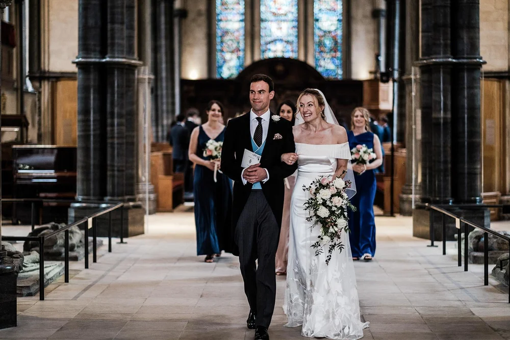 Gina and Ollie walking back down the aisle after their ceremony at Temple Church