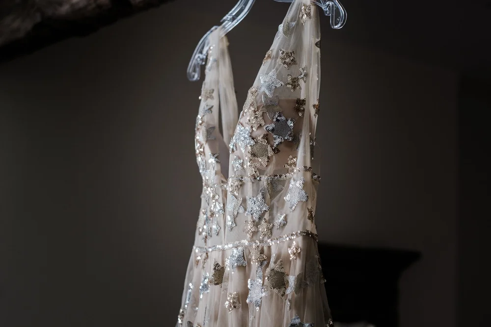 Jess&rsquo;s sequinned wedding dress hanging before the ceremony at Lyde Court