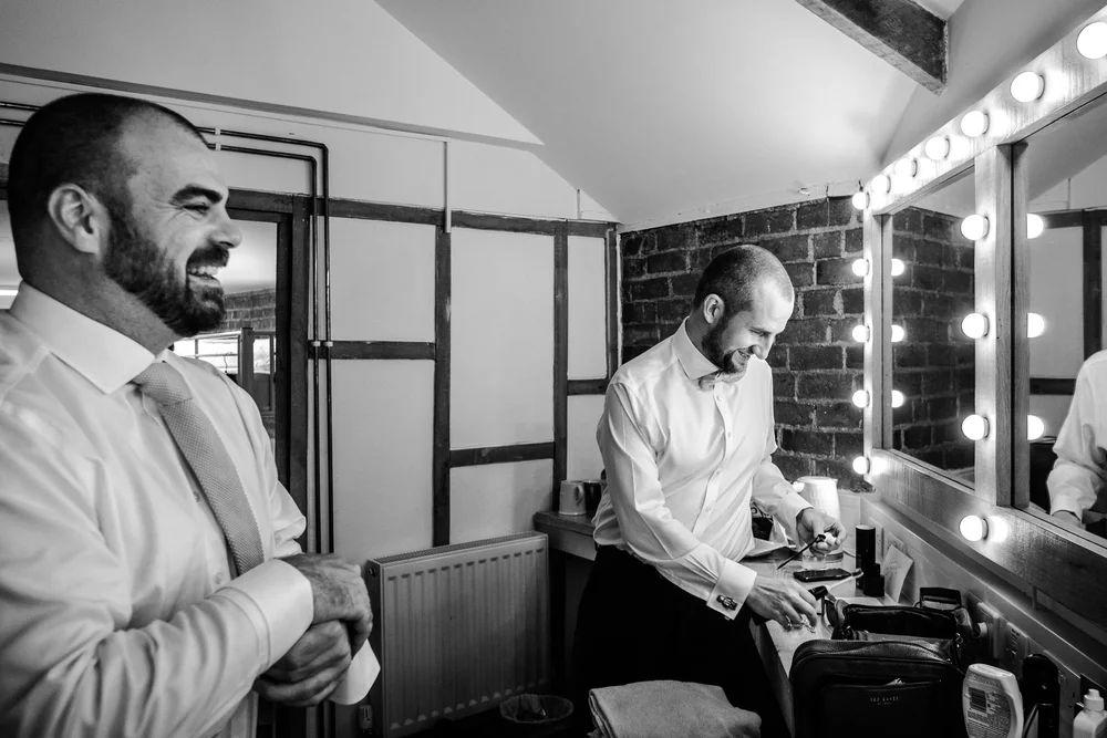 Black and white photograph of Tom and a groomsman getting ready