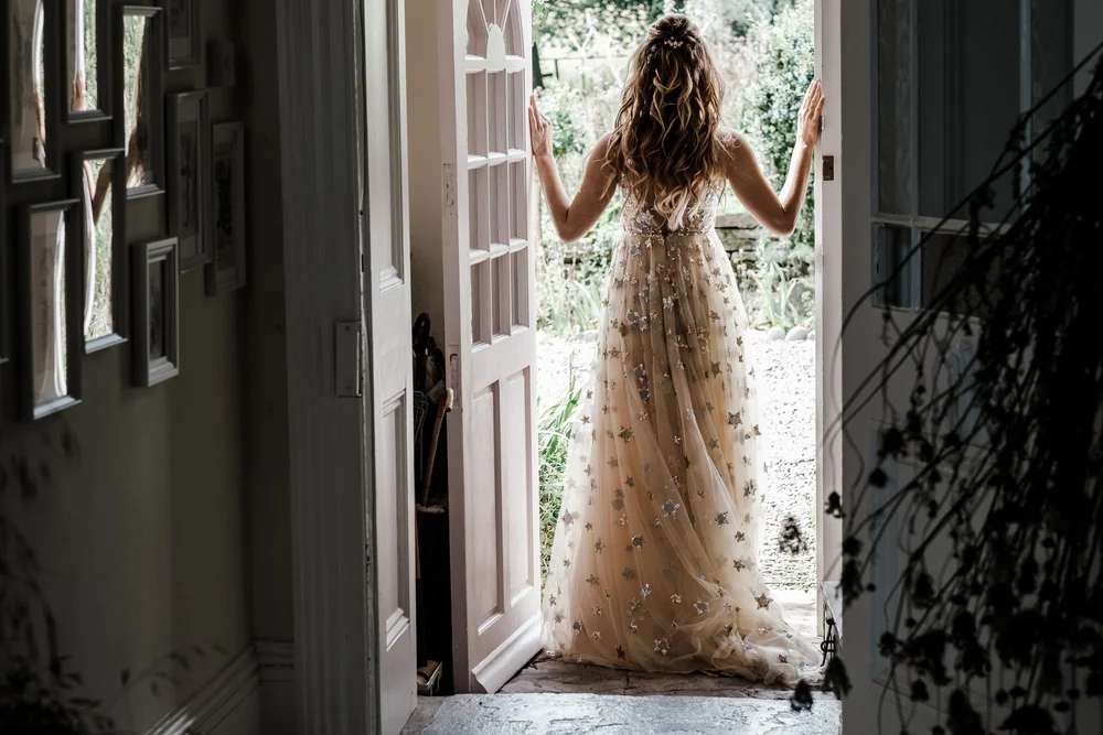 Jess standing in the doorway in her gold sequinned wedding dress