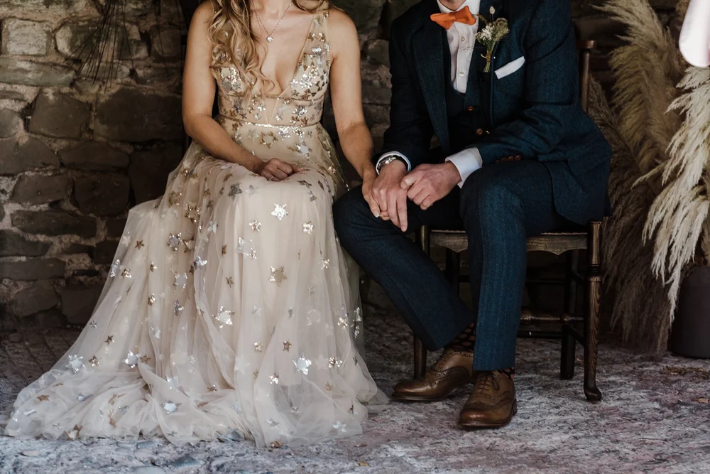 Jess and Tom sitting together during their humanist ceremony at Lyde Court