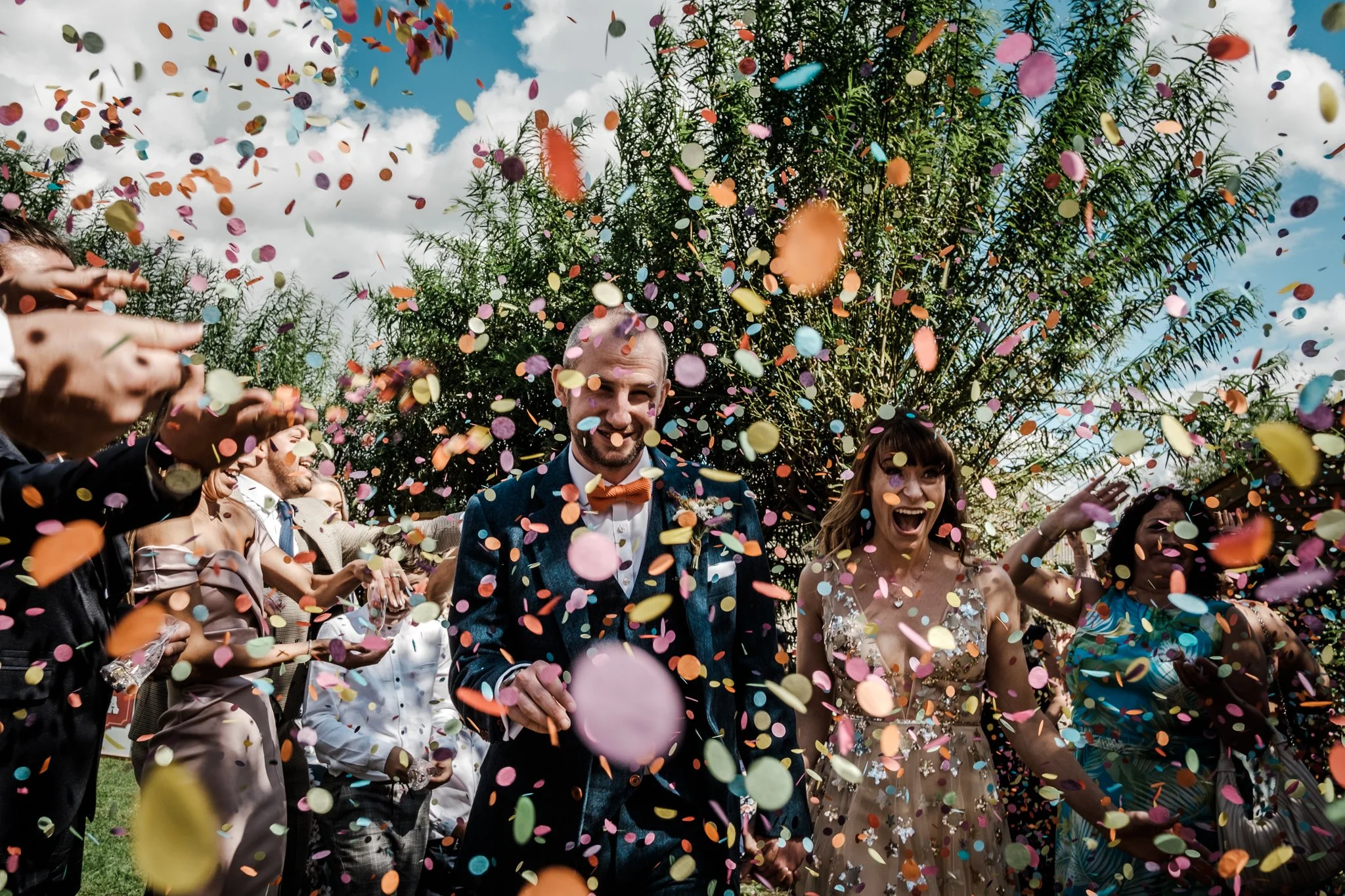 Jess and Tom in an enormous shower of colourful confetti at Lyde Court in Herefordshire