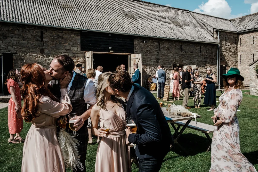 Guests on the lawn outside the stone barns at Lyde Court in Herefordshire