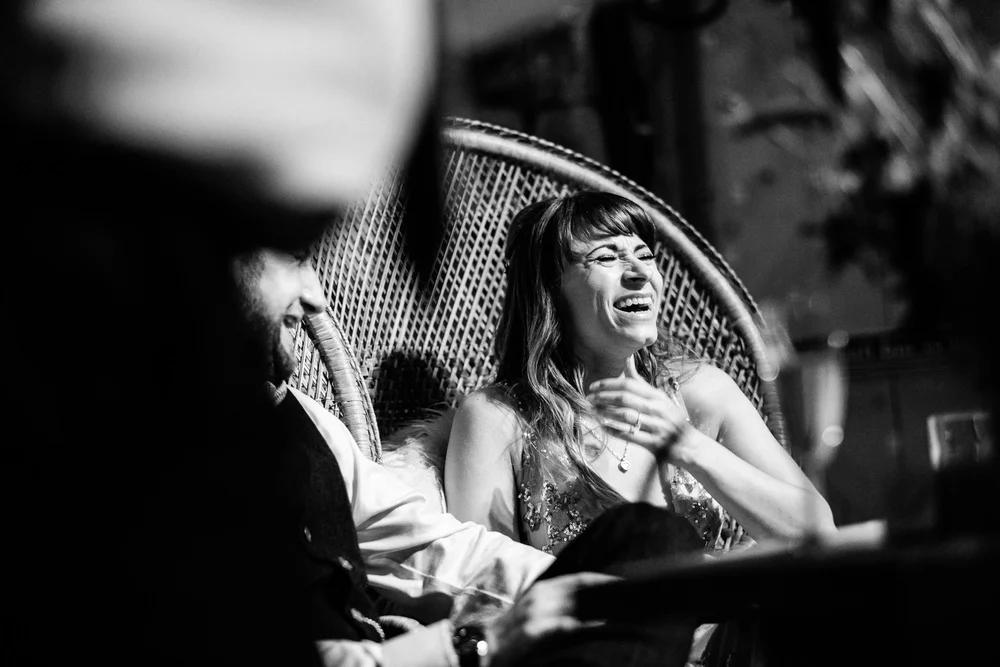 Black and white photograph of Jess laughing during the speeches