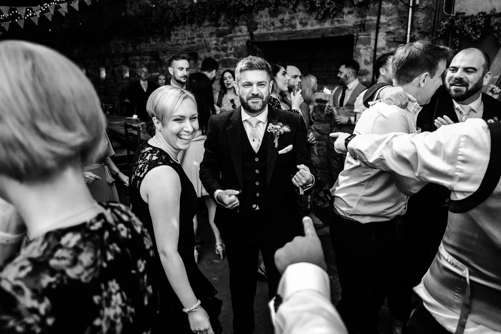 Black and white photograph of guests dancing in the barn at Lyde Court