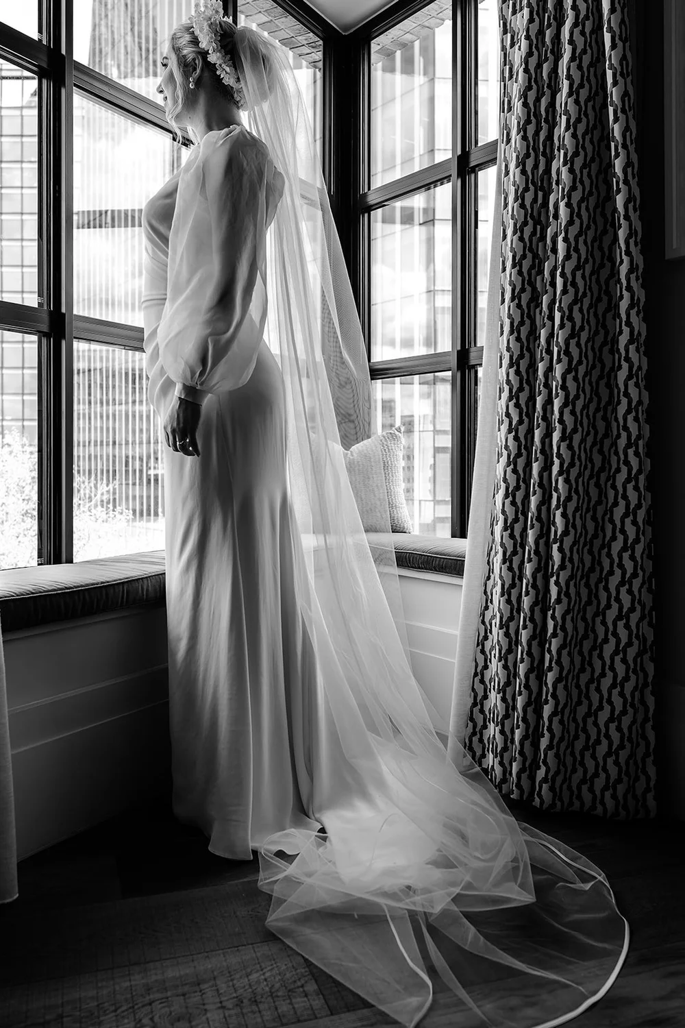 Black and white photograph of Meg&rsquo;s wedding dress hanging in the window