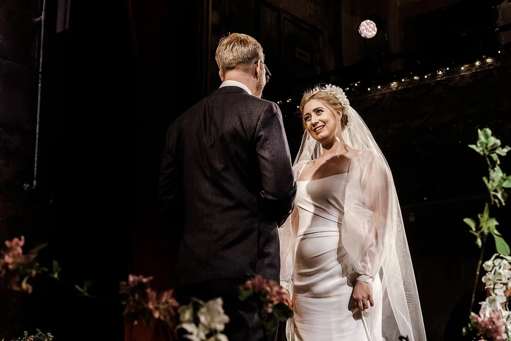 Meg and Jamie facing each other on the stage at Wilton&rsquo;s Music Hall