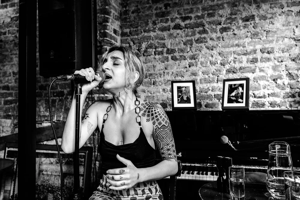 Black and white photograph of a singer performing at Meg and Jamie&rsquo;s wedding