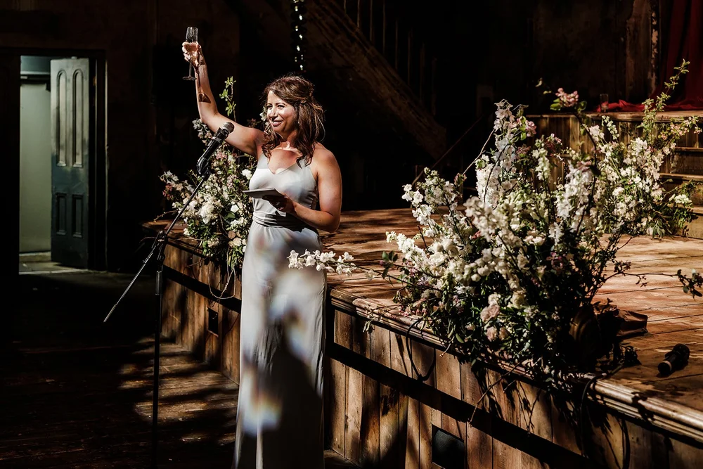 A guest laughing beside the flowers along the bar at Wilton&rsquo;s Music Hall
