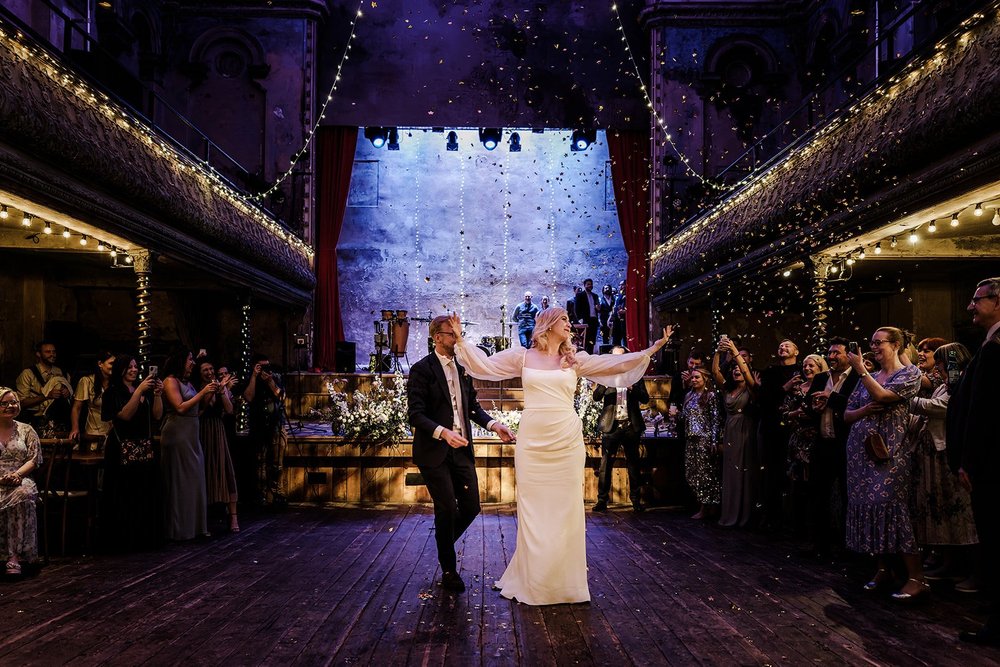Meg and Jamie on the stage with guests gathered around at Wilton&rsquo;s Music Hall