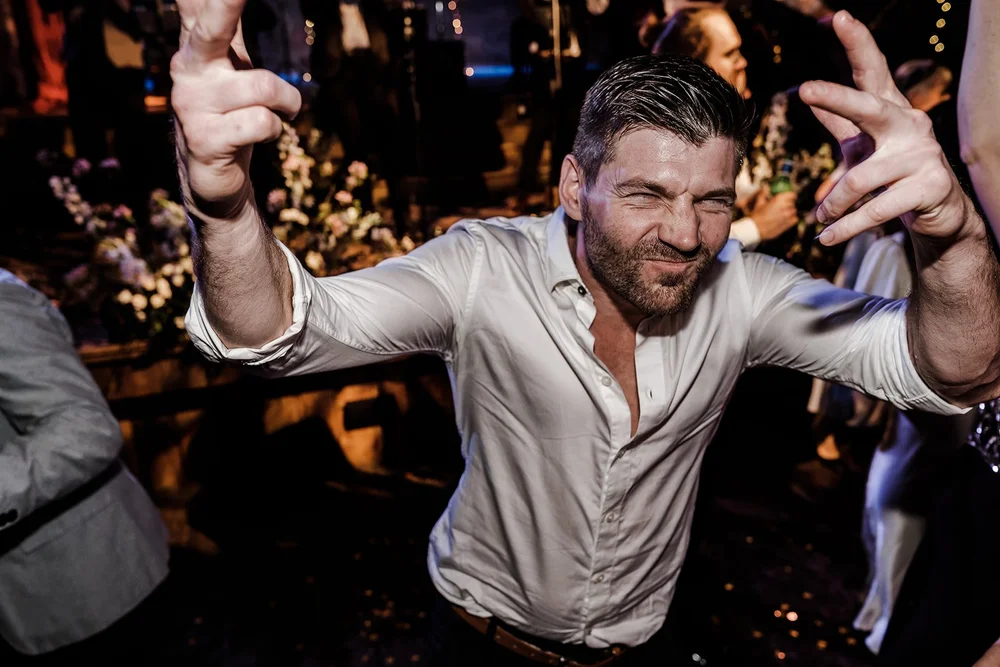A guest dancing with his arms out at the end of the night