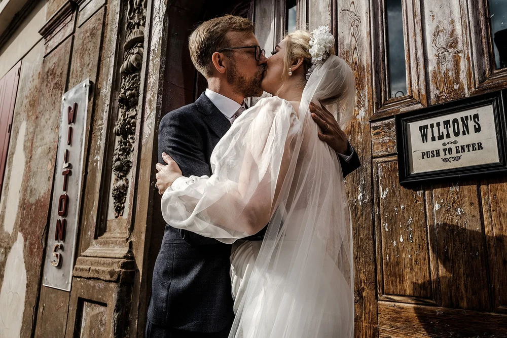 Meg and Jamie kissing beside the Wilton&rsquo;s Music Hall sign