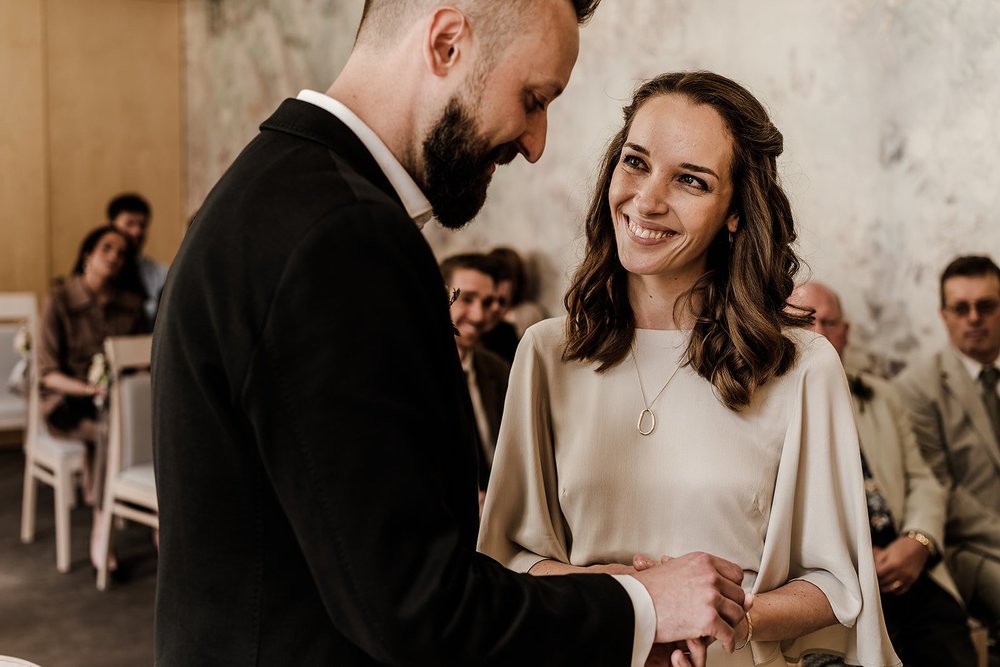 Aidan and Charlotte smiling at one another as they say their vows