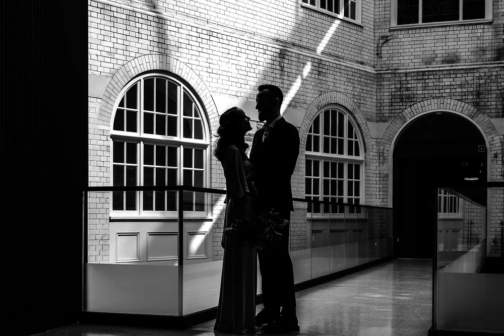 Black and white silhouette of Aidan and Charlotte in the Lambeth Town Hall walkway