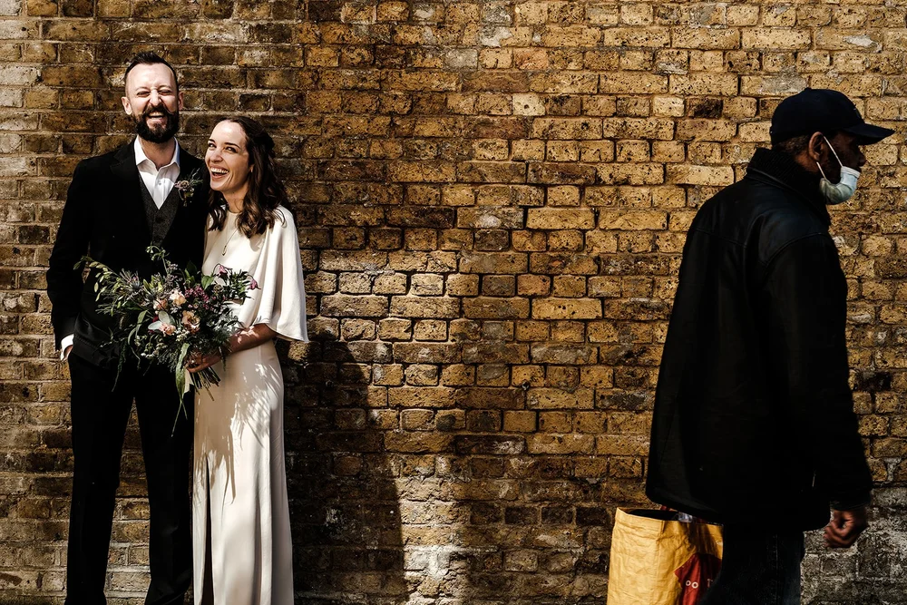 Aidan and Charlotte with her bouquet against the brickwork outside Lambeth Town Hall