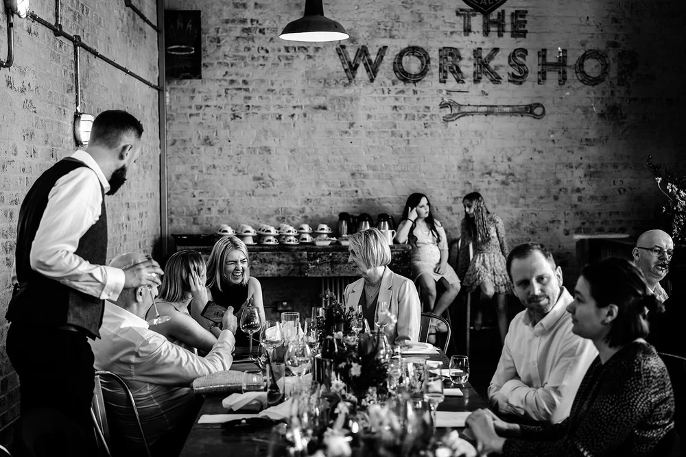 Black and white photograph of the long table during dinner at The Workshop at the Half Moon