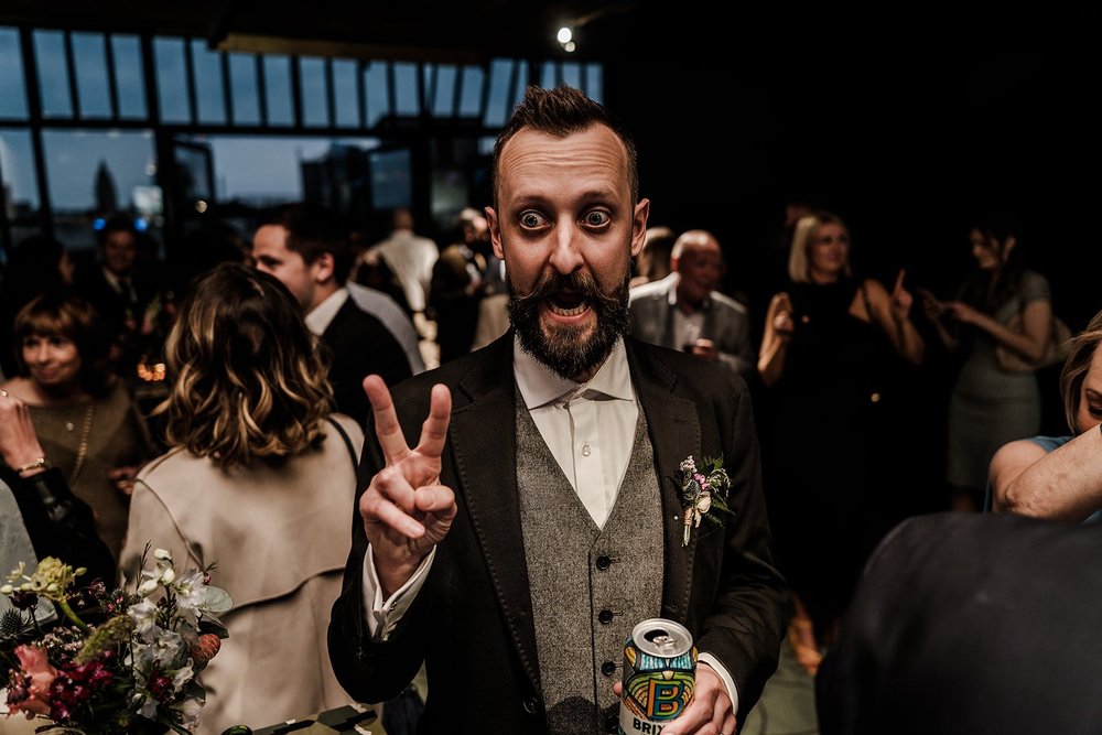 A guest with a drink on the dance floor at the end of the night